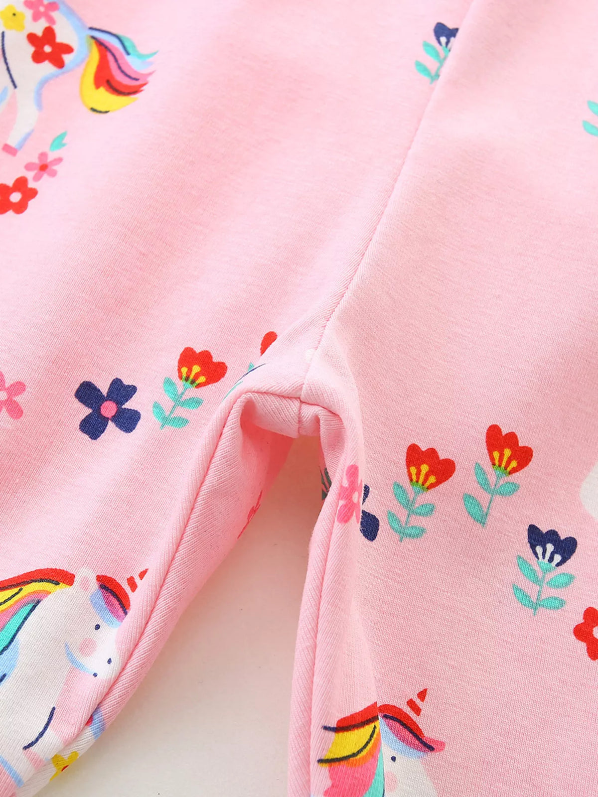 Unicorns and small flowers on pink fabric