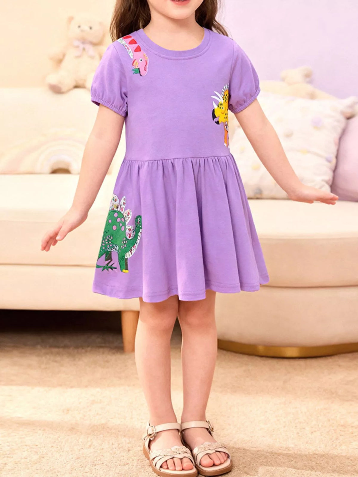 Lavender short-sleeve dress with dinosaur appliques on a child