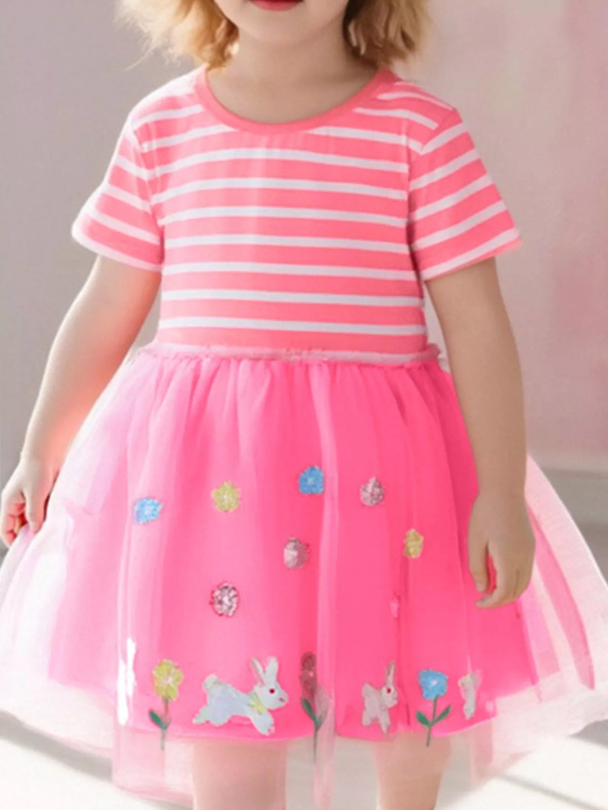 Pink striped short-sleeve dress with a bunny-applique tulle skirt on a child