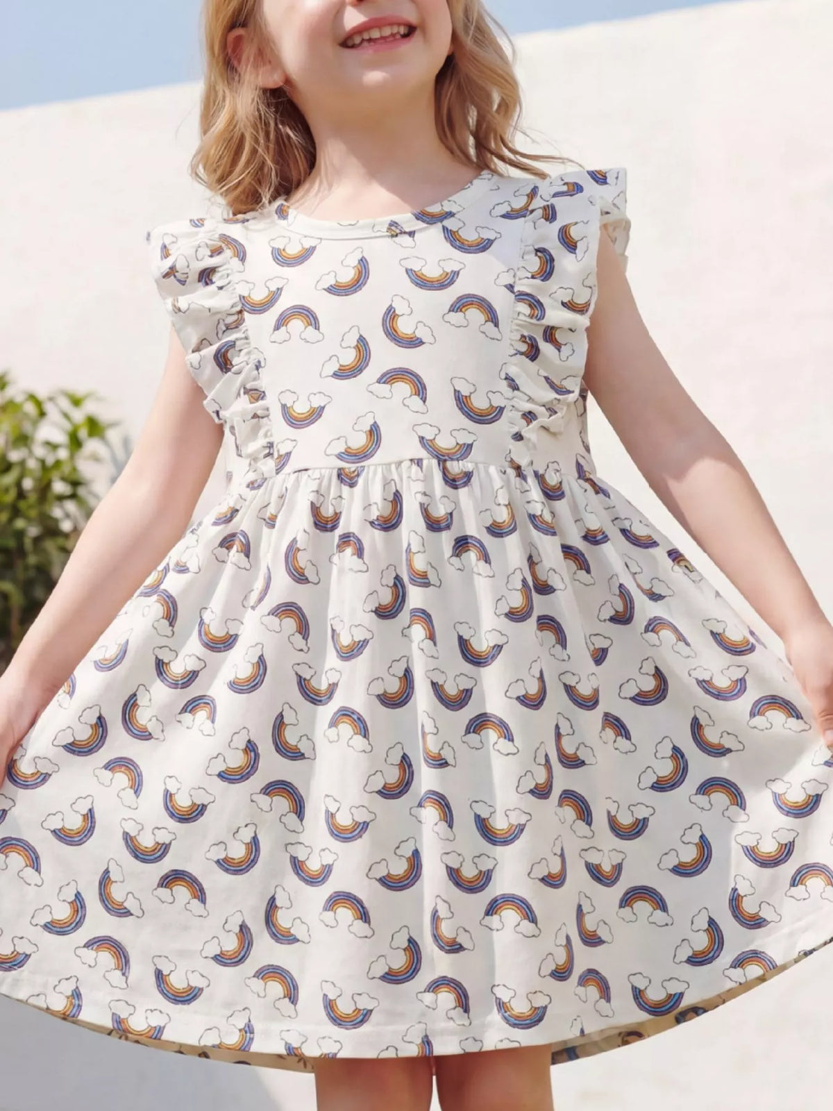 Pale rainbow-print dress with ruffled sleeves on a child