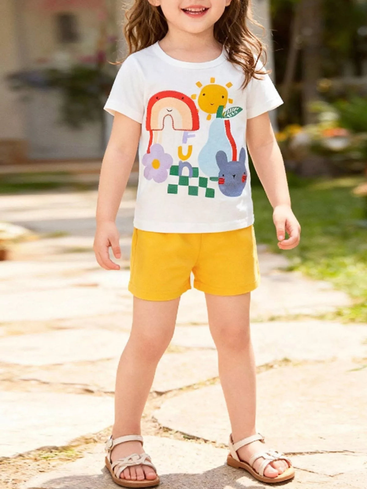 White colorful cartoon tee with yellow shorts on a child