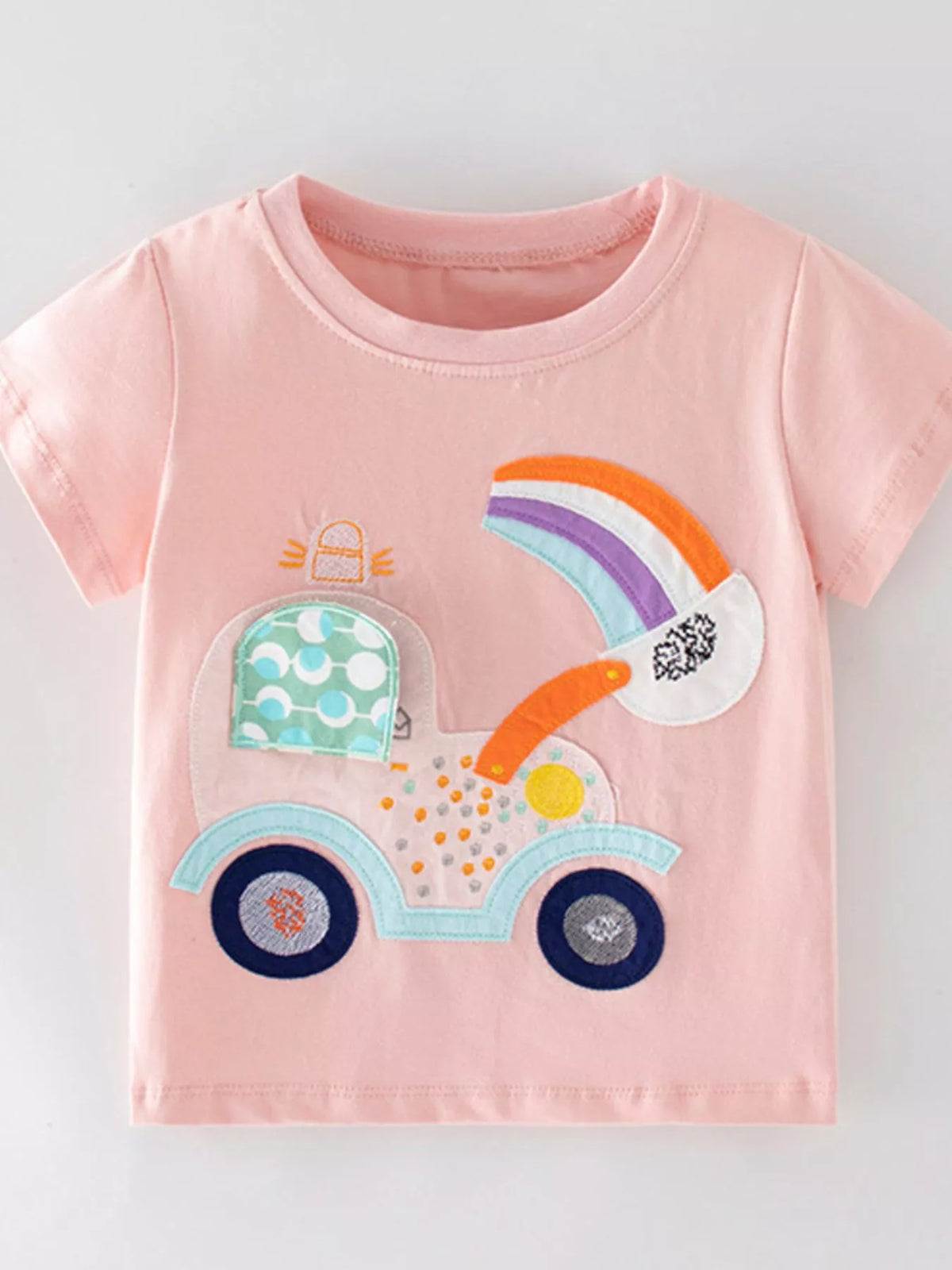 Peach rainbow vehicle applique shirt — front laid flat