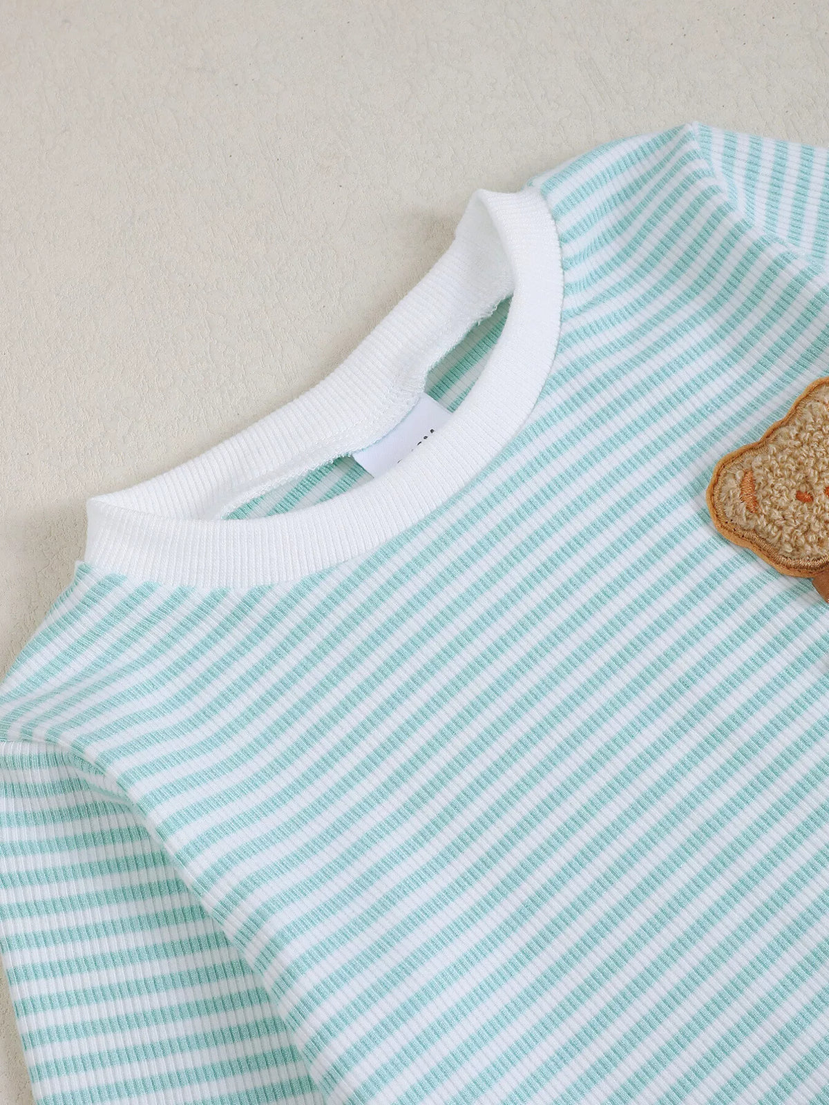 White neckline and bear applique on pale blue stripes