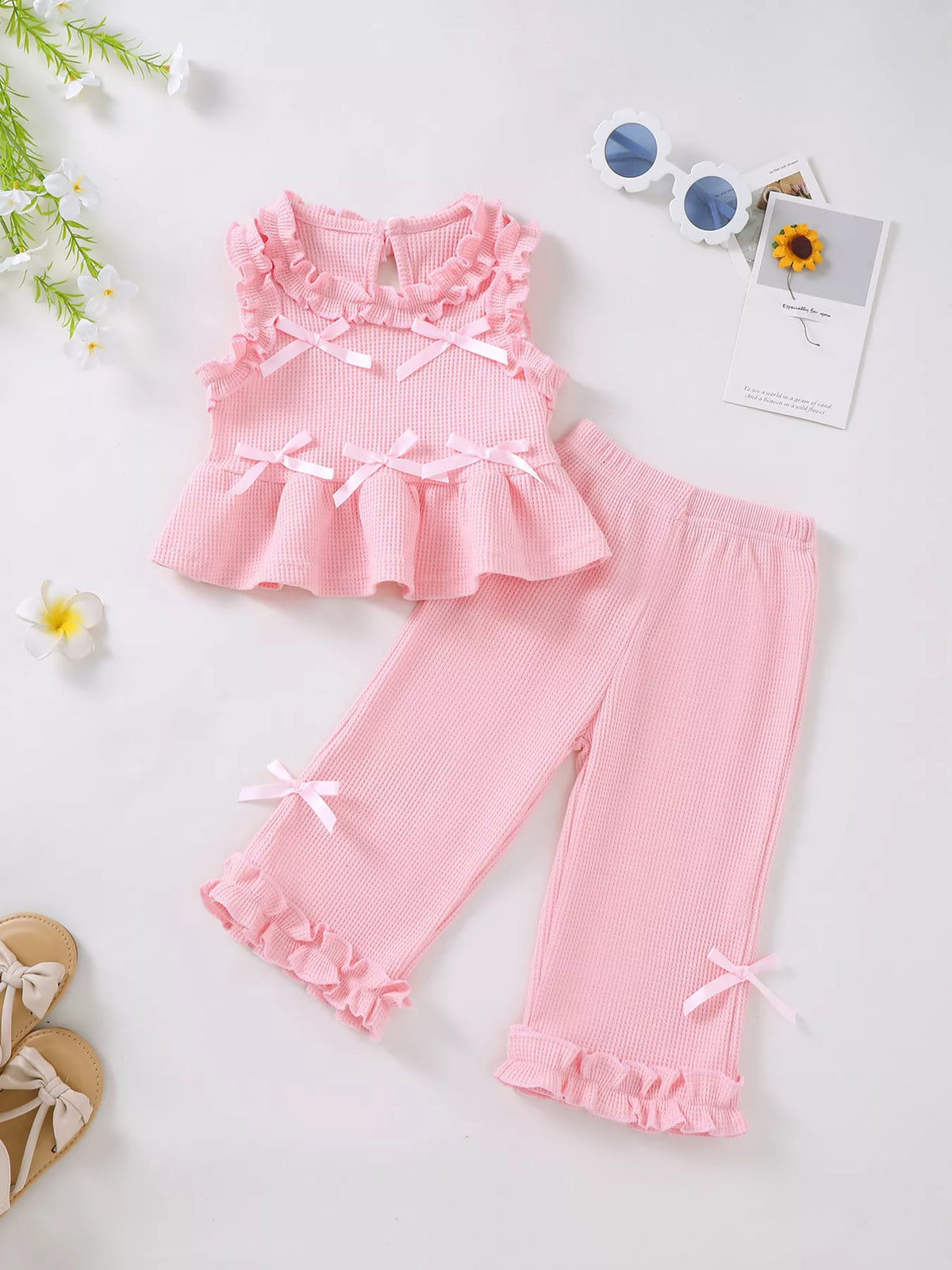 Pink bow top and pants laid flat