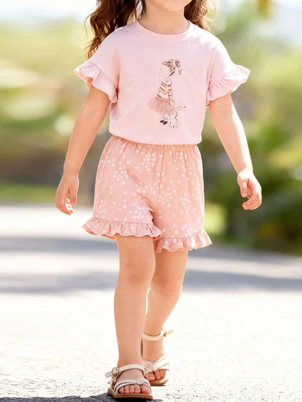 Pink ruffle-sleeve girl-and-bunny tee with floral shorts on a child